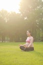 Asian Eastern Chinese young pretty pregnant girl woman do yoga sit in meditation, do lotus gesture of yoga over sunset,namaste Royalty Free Stock Photo