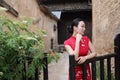 Asian Eastern oriental Chinese woman beauty in traditional ancient dress costume red cheongsam in ancient town garden fence