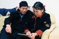 Asian elder couple playing with touchscreen tablet