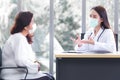 Asian elder female consults with professional doctor about her symptom or health problem in examination room at hospital Royalty Free Stock Photo