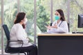 Asian elder female consults with professional doctor about her symptom or health problem in examination room at hospital Royalty Free Stock Photo