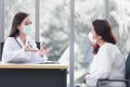 Asian elder female consults with professional doctor about her symptom or health problem in examination room at hospital Royalty Free Stock Photo