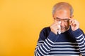 Asian elder man crying raise glasses with tissue wipe red eyes Royalty Free Stock Photo