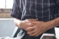 Asian man suffering from abdominal pain. It can be caused by stomach ache, enteritis, colitis, appendicitis, hepatitis,