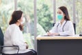 Asian elder woman consults with professional doctor about her symptom or health problem in examination room at hospital Royalty Free Stock Photo