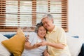 Asian elderly couple man holding cake celebrating wife`s birthday in living room at home. Japanese couple enjoy love moment Royalty Free Stock Photo