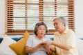 Asian elderly couple man holding cake celebrating wife`s birthday in living room at home. Japanese couple enjoy love moment Royalty Free Stock Photo