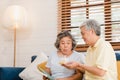 Asian elderly couple man holding cake celebrating wife`s birthday in living room at home. Japanese couple enjoy love moment Royalty Free Stock Photo