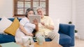 Asian elderly couple using tablet watching TV in living room at home, couple enjoy love moment while lying on sofa when relaxed at Royalty Free Stock Photo