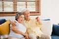 Asian elderly couple watching television in living room at home, sweet couple enjoy love moment while lying on the sofa when Royalty Free Stock Photo