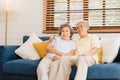 Asian elderly couple watching television in living room at home, sweet couple enjoy love moment while lying on the sofa when Royalty Free Stock Photo