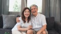 Asian elderly couple watching television in living room at home, sweet couple enjoy love moment while lying on the sofa when Royalty Free Stock Photo