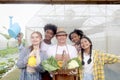 Asian elderly farmer hold fresh harvest fruit vegetable basket with multiethnic teenager friend group with garden tools watering