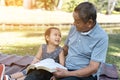 Asian elderly having faith to the Lord, God reading bible outdoor with kid