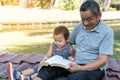 Asian elderly having faith to the Lord, God reading bible outdoor with kid