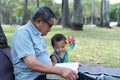 Asian elderly having faith to the Lord, God reading bible outdoor with kid