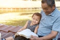 Asian elderly having faith to the Lord, God reading bible outdoor with kid