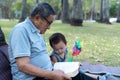 Asian elderly having faith to the Lord, God reading bible outdoor with kid