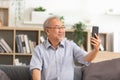 Asian elderly man making video call on smart phone, online call,  digital technology service consultation while staying at home. Royalty Free Stock Photo