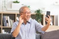 Asian elderly man making video call on smart phone, online call,  digital technology service consultation while staying at home. Royalty Free Stock Photo