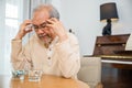 Asian elderly man sick have headache looking pill glass on at home Royalty Free Stock Photo