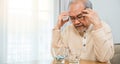 Asian elderly man sick have headache looking pill glass on at home Royalty Free Stock Photo