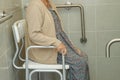 Asian elderly old woman patient use toilet support rail in bathroom, handrail safety grab bar, security in nursing hospital