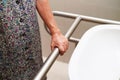 Asian elderly old woman patient use toilet support rail in bathroom, handrail safety grab bar, security in nursing hospital