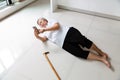 Asian elderly people with walking stick and using the phone to call for help,sick senior woman with headache,backache lying on the Royalty Free Stock Photo