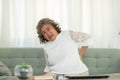 Asian Elderly senior woman back pain and illness on sofa alone at home,unhappy elderly touch on back serious and tried,Elderly Royalty Free Stock Photo