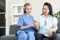 Asian elderly senior woman clenched her hands tightly and cute nurse hold senior woman hand and suggests during physical therapy Royalty Free Stock Photo