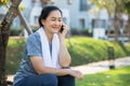 Asian elderly or senior woman talking mobile phone in garden. Royalty Free Stock Photo