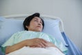 Asian elderly woman lying on bed with anxious and worried expression face at hospital