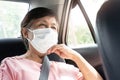 Asian Elderly woman Passenger wear protective or surgical mask for prevent coronavirus or Covid-19 while sitting in car