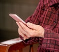 Asian elderly woman sitting and looking through something on modern smartphone, making connection with others at home, living Royalty Free Stock Photo