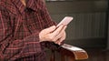 Asian elderly woman sitting and looking through something on modern smartphone, making connection with others at home, living Royalty Free Stock Photo