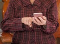 Asian elderly woman sitting and looking through something on modern smartphone, making connection with others at home, living Royalty Free Stock Photo