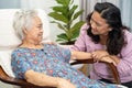 Asian elderly woman sitting relaxing with caregiver in rocking chair at room in home Royalty Free Stock Photo