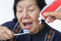 Asian elderly woman trying use toothbrush ,hand tremor