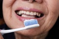 Asian elderly woman trying use toothbrush ,hand tremor