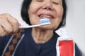 Asian elderly woman trying use toothbrush. Dental