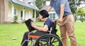 Asian elderly woman reading a book with her son take care in backyard Royalty Free Stock Photo