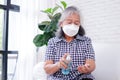 Asian elderly women wearing white masks Spray alcohol on your hands Royalty Free Stock Photo