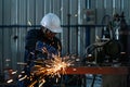 Asian electric wheel grinding on steel structure in factory. heavy industry workers factory interior with industrial worker using Royalty Free Stock Photo