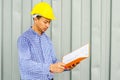 Asian Electrical Engineer holding files while wearing a personal protective equipment safety helmet Royalty Free Stock Photo