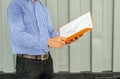 Electrical Engineer holding files while wearing a personal protective equipment safety helmet at construction site. Royalty Free Stock Photo