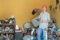 Asian electronics repairman smiles at the camera while using his tablet pc around electronic parts