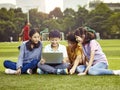 Asian elementary school children using laptop outdoors Royalty Free Stock Photo