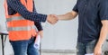 Asian Engineer and architect handshake at construction property site. Teamwork and Successful building project Royalty Free Stock Photo