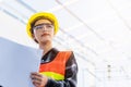 Asian engineer architect worker woman holding blueprint infrastructure progress at construction site Royalty Free Stock Photo